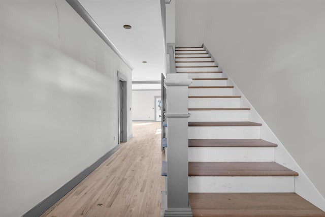 stairs featuring wood finished floors and baseboards