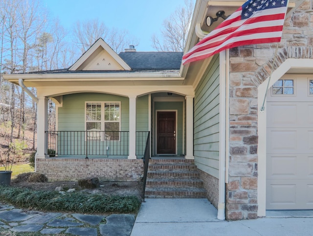 doorway to property with covered porch, a garage, a shingled roof, stone siding, and a chimney