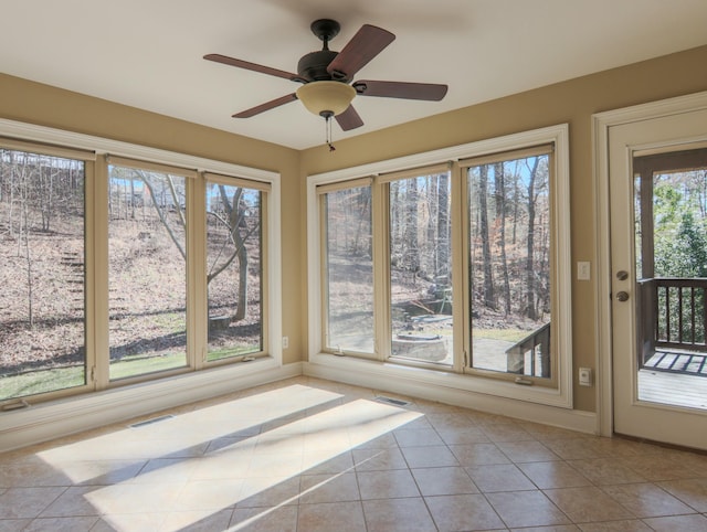 unfurnished sunroom with visible vents and ceiling fan