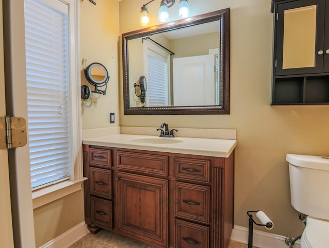 bathroom with toilet, baseboards, and vanity