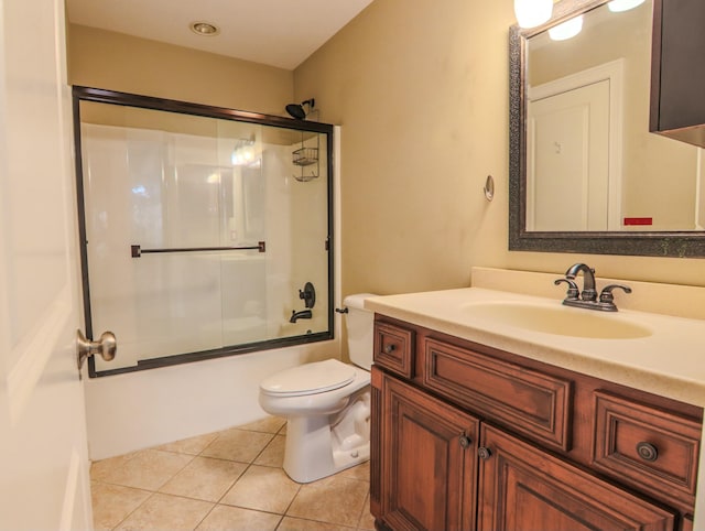 full bath with bath / shower combo with glass door, vanity, toilet, and tile patterned floors