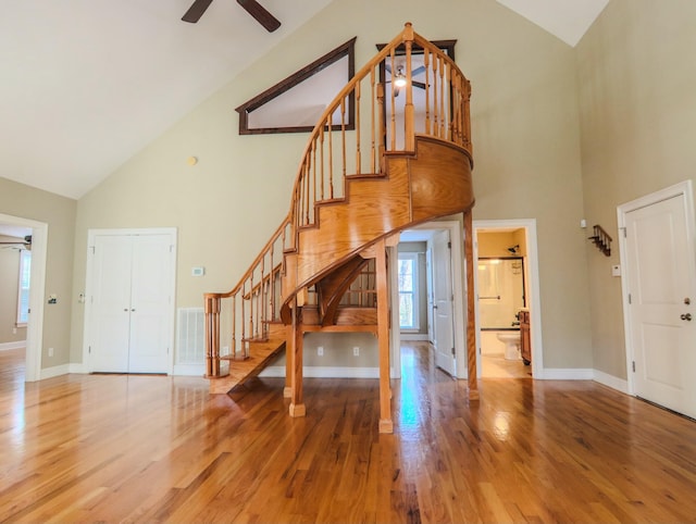 entrance foyer featuring light wood-style floors, ceiling fan, stairway, and high vaulted ceiling