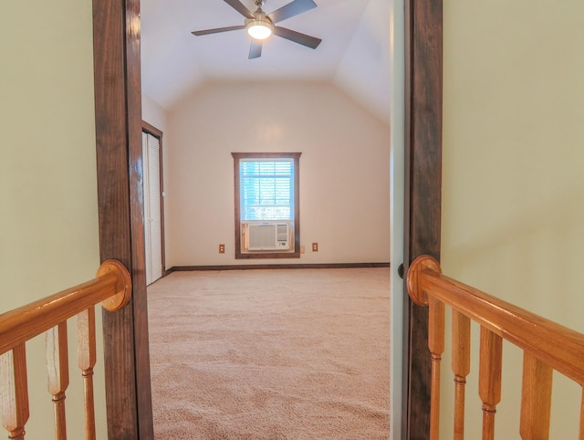 empty room with ceiling fan, cooling unit, carpet floors, baseboards, and vaulted ceiling