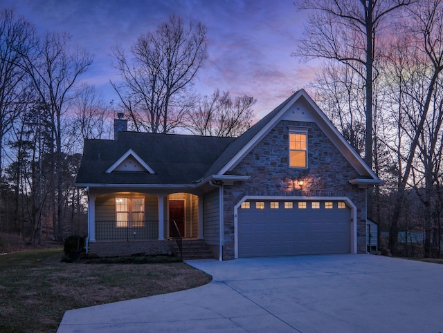 view of front facade featuring a chimney, covered porch, concrete driveway, an attached garage, and stone siding