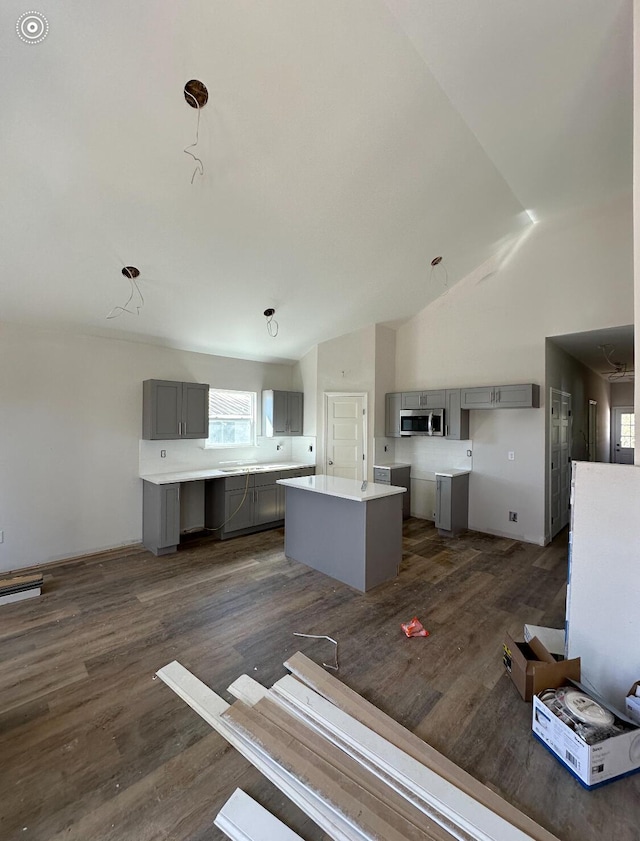 kitchen featuring lofted ceiling, dark wood-type flooring, gray cabinets, and a center island