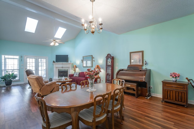 dining room featuring a skylight, a fireplace, baseboards, and wood finished floors