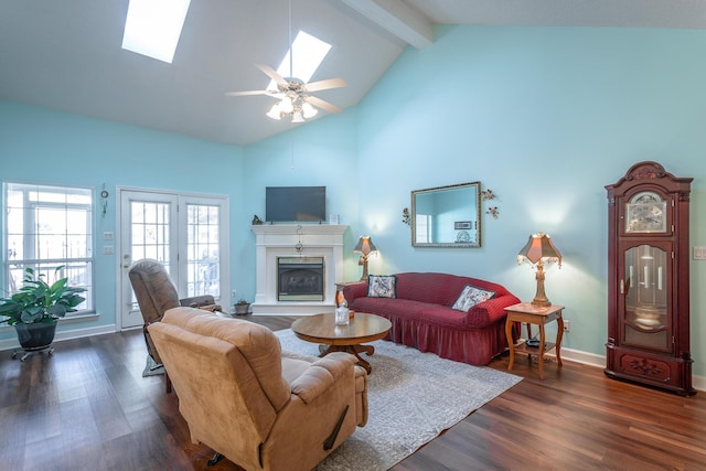 living area with a fireplace with raised hearth, high vaulted ceiling, dark wood-style flooring, a skylight, and beam ceiling