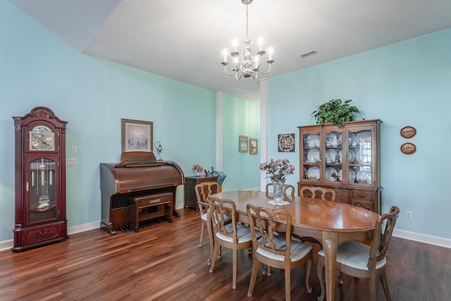 dining area with a notable chandelier, visible vents, baseboards, and wood finished floors