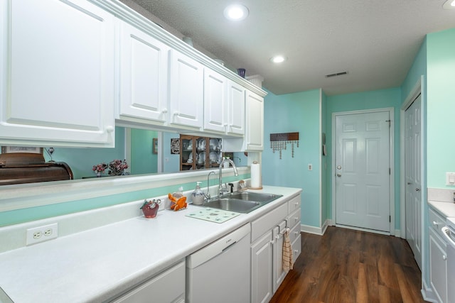 kitchen with white dishwasher, a sink, visible vents, white cabinetry, and light countertops