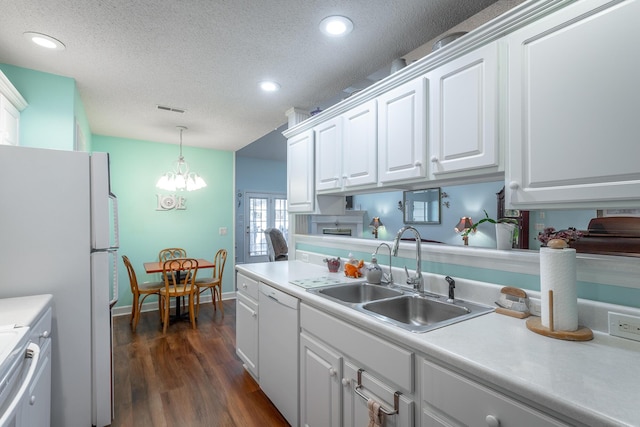 kitchen featuring a textured ceiling, white appliances, a sink, white cabinets, and light countertops