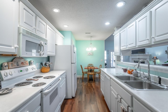 kitchen with white appliances, white cabinetry, light countertops, and a sink