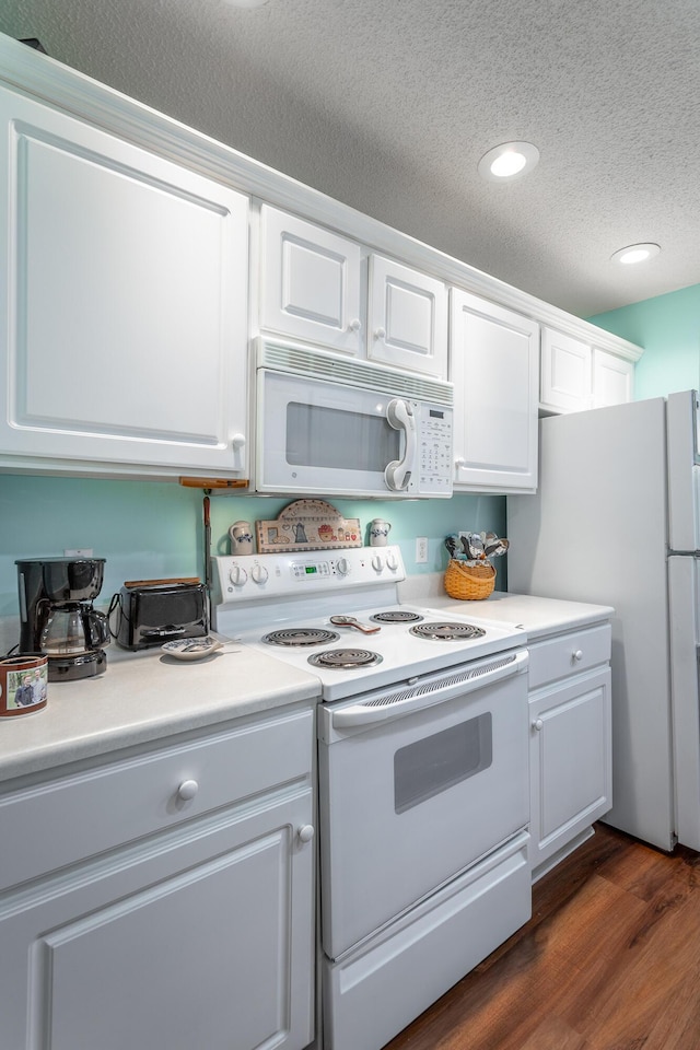 kitchen with a textured ceiling, white appliances, dark wood-type flooring, white cabinetry, and light countertops