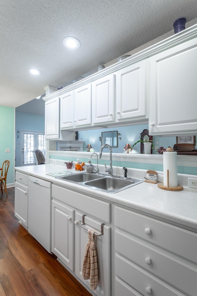 kitchen featuring dishwasher, dark wood-style floors, a textured ceiling, white cabinetry, and a sink