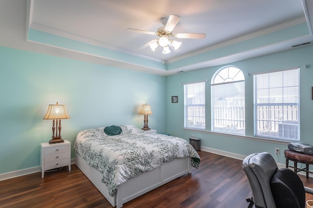 bedroom with dark wood-type flooring, a raised ceiling, visible vents, and baseboards