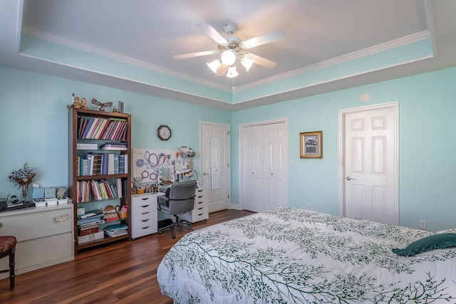 bedroom featuring ornamental molding, a raised ceiling, and dark wood finished floors