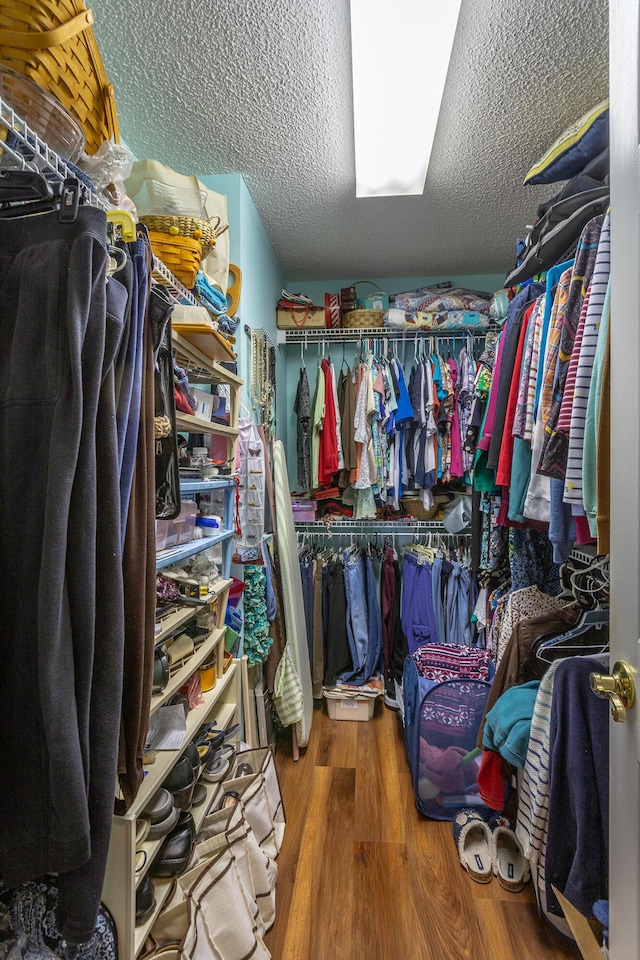 walk in closet with wood finished floors