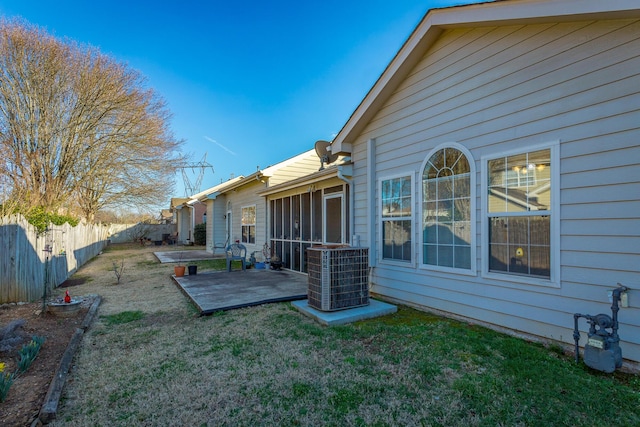 view of yard featuring a patio area, fence, central AC unit, and a sunroom