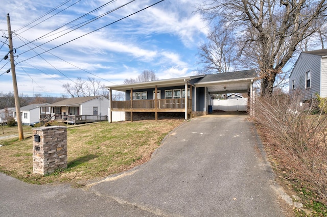 single story home with a front lawn, aphalt driveway, an attached carport, and a wooden deck