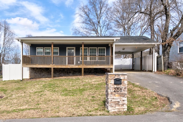 view of front of property featuring aphalt driveway, a porch, an attached carport, fence, and a front lawn