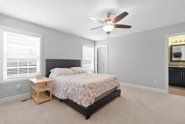 bedroom featuring light carpet, visible vents, baseboards, and multiple windows