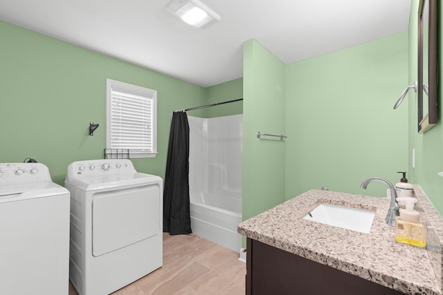 clothes washing area with washer and clothes dryer and a sink