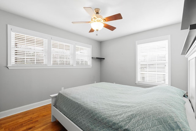 bedroom featuring a ceiling fan, baseboards, and wood finished floors