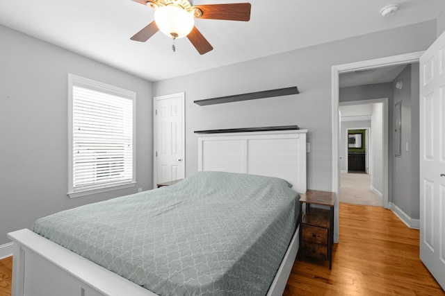 bedroom with ceiling fan, wood finished floors, and baseboards