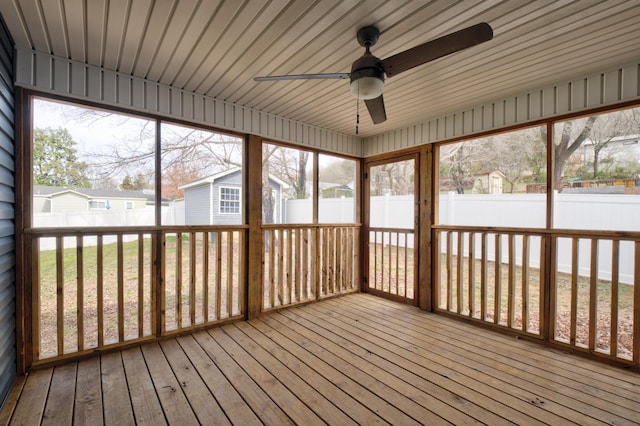 unfurnished sunroom featuring a ceiling fan