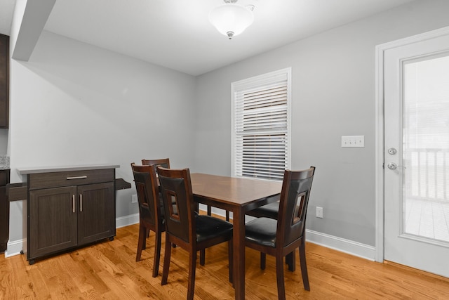 dining space featuring baseboards and light wood-style floors