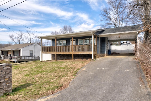 single story home featuring driveway, a porch, a carport, and a front yard