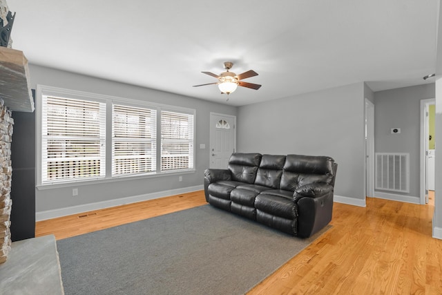 living area with visible vents, baseboards, and wood finished floors