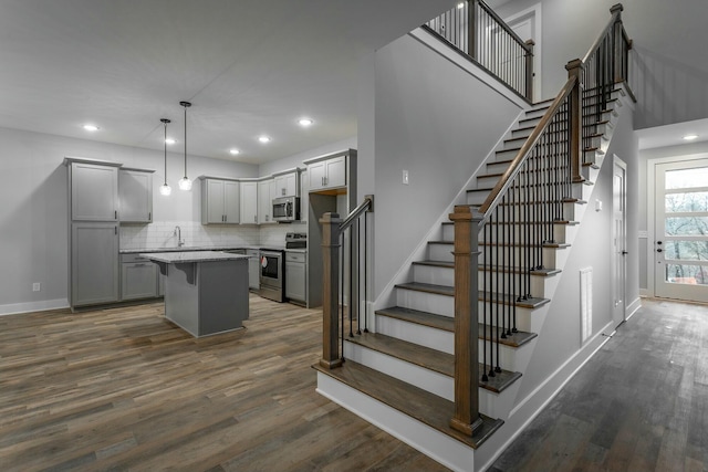 staircase with recessed lighting, wood finished floors, visible vents, and baseboards