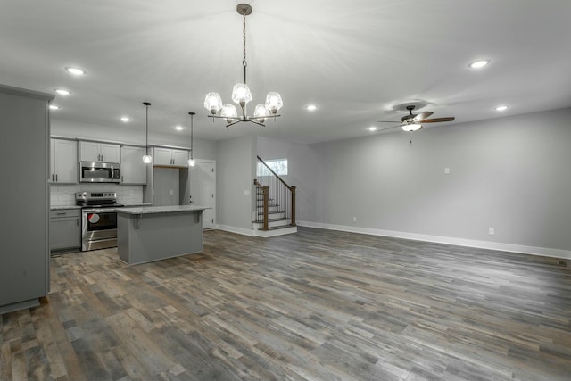 kitchen featuring a center island, dark wood-style flooring, gray cabinets, appliances with stainless steel finishes, and open floor plan