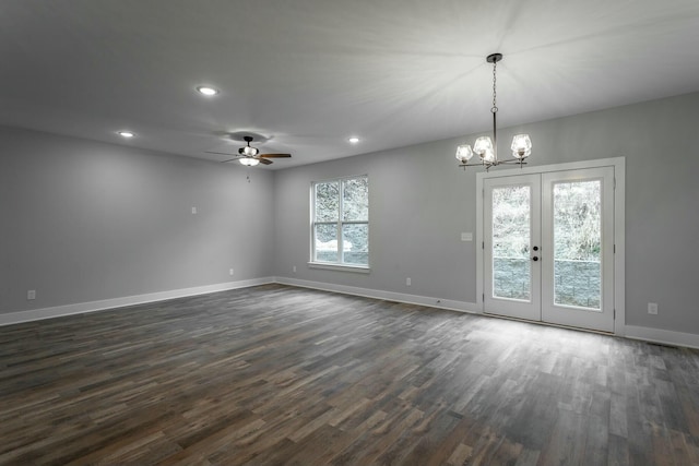 spare room featuring recessed lighting, ceiling fan with notable chandelier, dark wood-style flooring, baseboards, and french doors