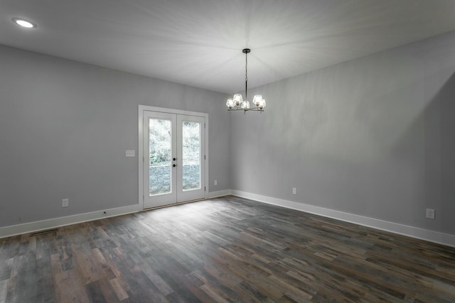 unfurnished room featuring a chandelier, french doors, dark wood finished floors, and baseboards