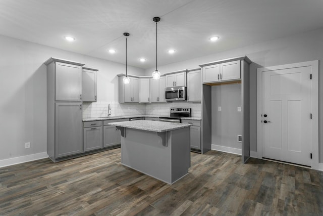 kitchen with tasteful backsplash, appliances with stainless steel finishes, dark wood-type flooring, and gray cabinetry