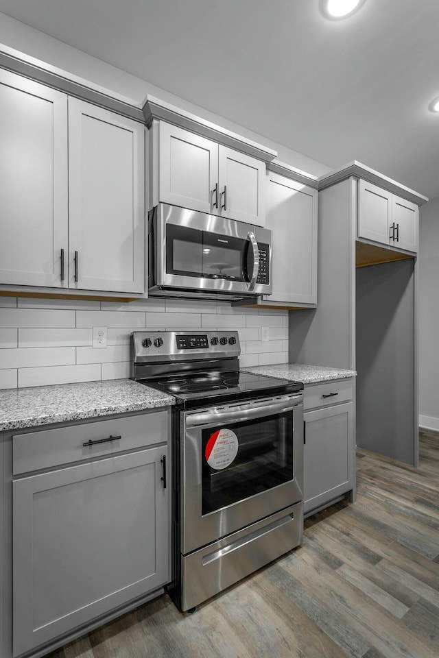 kitchen with stainless steel appliances, backsplash, and gray cabinets