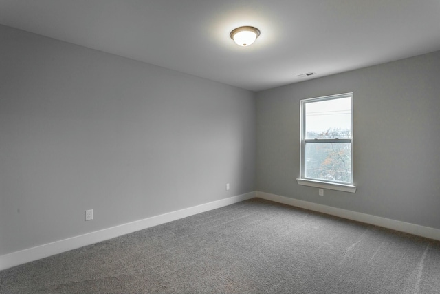 carpeted empty room featuring visible vents and baseboards