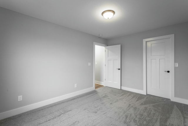 unfurnished bedroom featuring carpet floors and baseboards