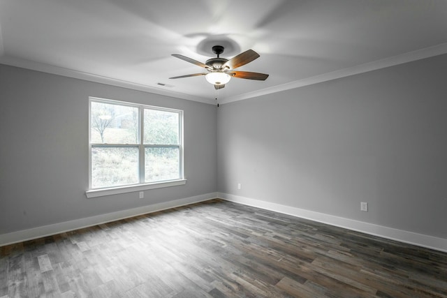 spare room featuring dark wood-style floors, ornamental molding, a ceiling fan, and baseboards