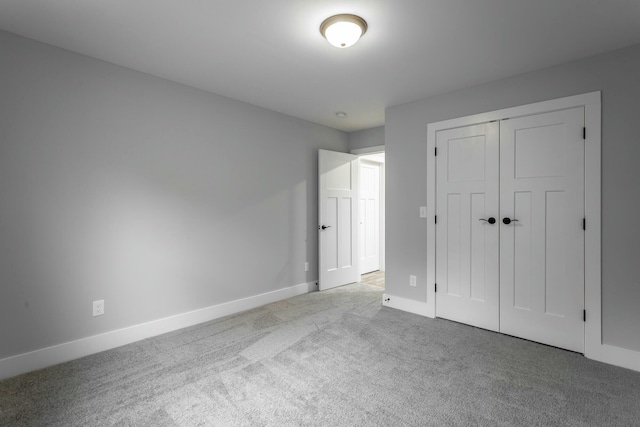 unfurnished bedroom featuring a closet, baseboards, and carpet flooring