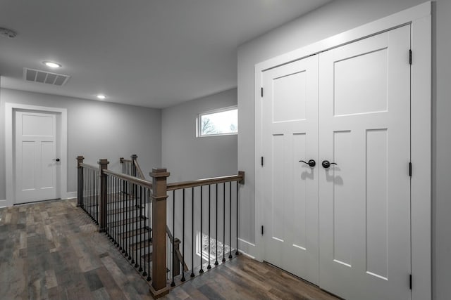 hall with recessed lighting, visible vents, an upstairs landing, and wood finished floors