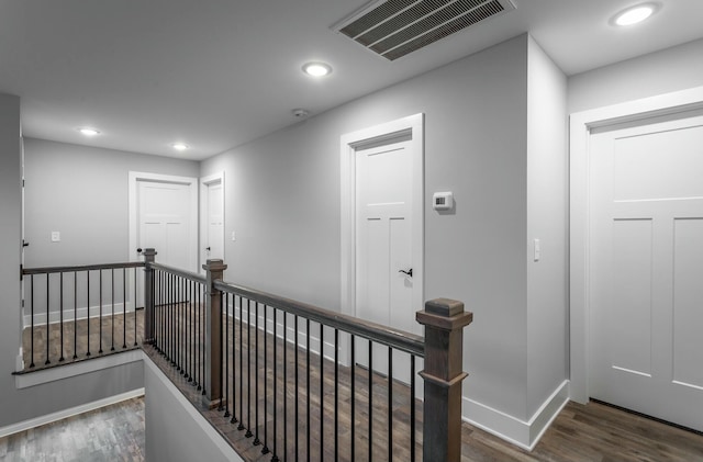 corridor with wood finished floors, an upstairs landing, visible vents, and recessed lighting