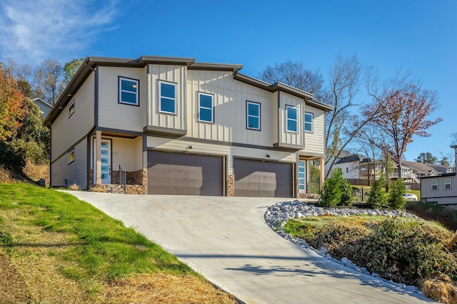 view of front of home featuring driveway, stone siding, a residential view, an attached garage, and board and batten siding