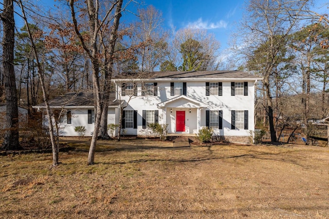 colonial-style house featuring a front lawn