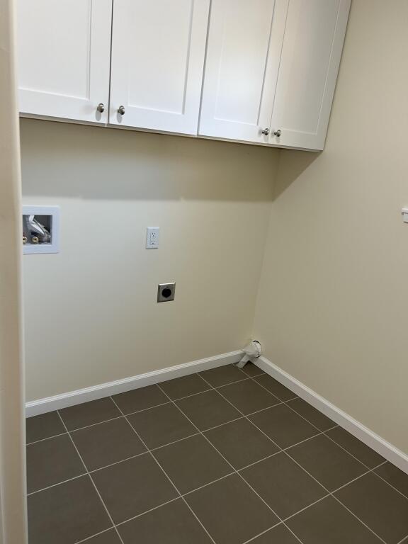 laundry room with cabinet space, hookup for a washing machine, baseboards, and electric dryer hookup