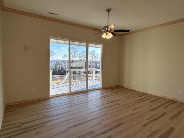 unfurnished room with baseboards, visible vents, ceiling fan, wood finished floors, and crown molding