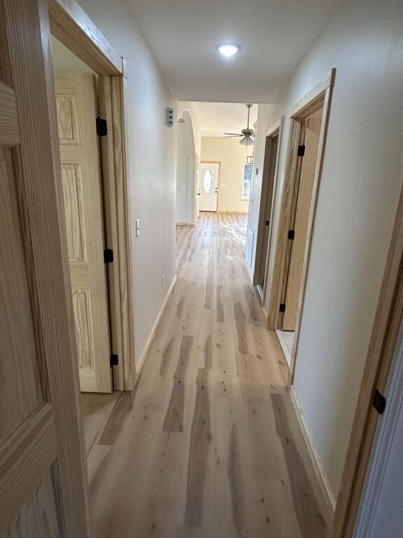 hallway with light wood-style floors and baseboards