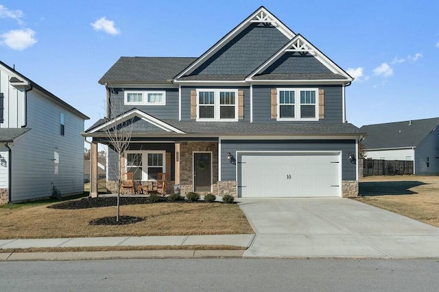 craftsman inspired home with an attached garage, concrete driveway, a porch, and stone siding