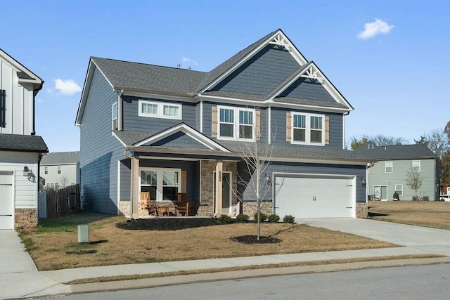 craftsman house with a porch, an attached garage, fence, stone siding, and driveway